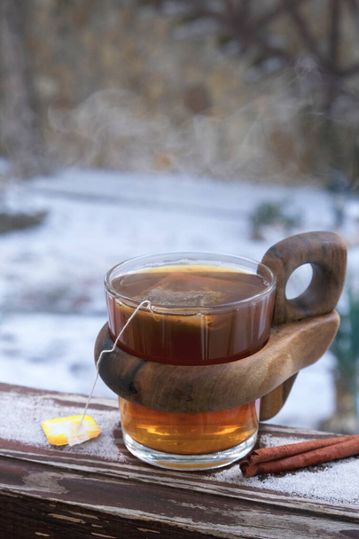 A cup of hot black tea on the snow. Tea time - Photo, Image