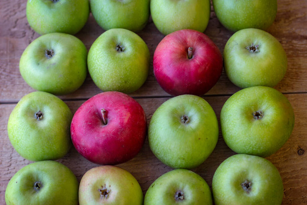 Vihreä ja punainen omenat seistä puupinnalla - Valokuva, kuva