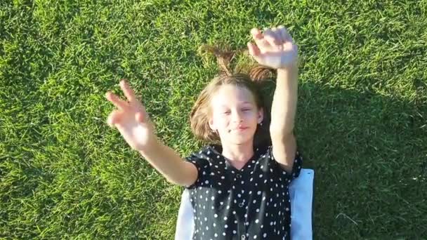 Pieni hymyilevä tyttö leikkii puistossa - Materiaali, video