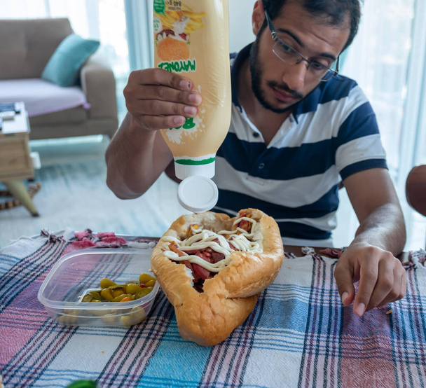 Sanduíche de salame caseiro com queijo e um homem está feliz por ter esta refeição - Foto, Imagem
