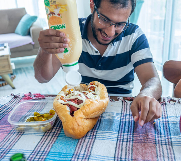 Hausgemachtes Salami-Sandwich mit Käse und ein Mann freut sich über diese Mahlzeit - Foto, Bild
