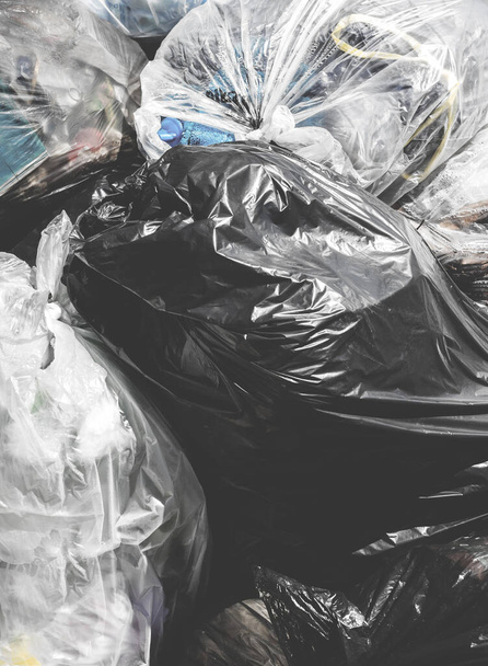 Vuilniszakken. Stapels afval in plastic vuilniszakken. Storten. Close-up voor achtergrond. Foto in retrostijl. - Foto, afbeelding