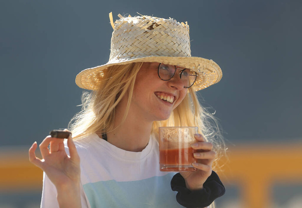 Una joven con un cigarro y una taza de bebida. Una chica con un sombrero de mantequilla. - Foto, imagen