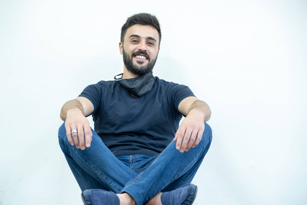 Арабський веселий чоловік, що сидить на підлозі, має гарну посмішку. - Фото, зображення