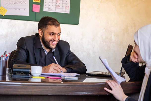 Entrevista de trabajo entre hombre y mujer musulmana usando hijab en la oficina - Foto, imagen