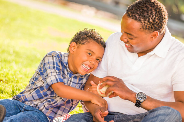 African American Father and Mixed Race Son Playing with Baseball in the Park. - Foto, Imagem