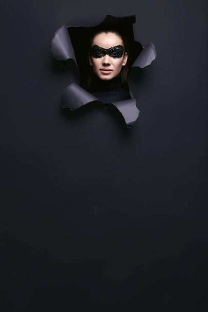 Muotokuva viehättävä tyylikäs brunette nainen musta poolopaita ja paljetit naamio näyttää revitty studio tausta - Valokuva, kuva