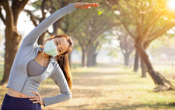Joven mujer asiática usar máscara y haciendo ejercicios  - Foto, imagen