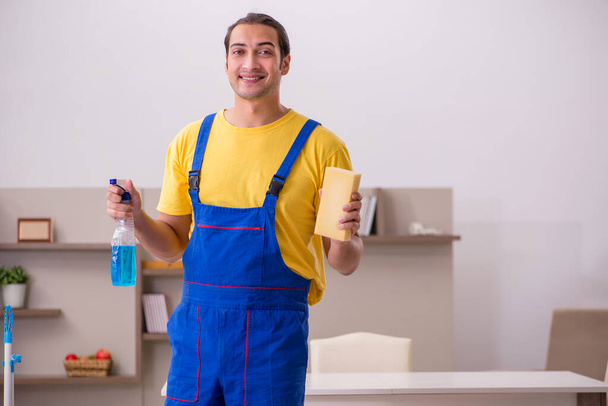 Nuori miespuolinen urakoitsija siivoamassa taloa - Valokuva, kuva