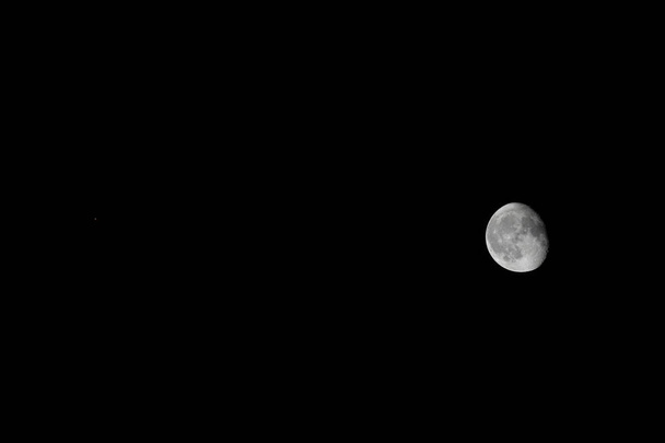 Marte (come un piccolo puntino rosso a sinistra) accanto ad una luna gibbosa calante in scala in un'unica immagine - Foto, immagini