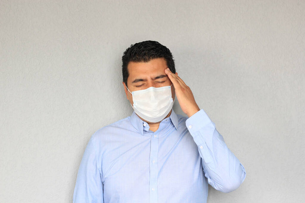 Официальный взрослый латинский мужчина с защитной маской, чиханием и ковид-19 симптомов - Фото, изображение