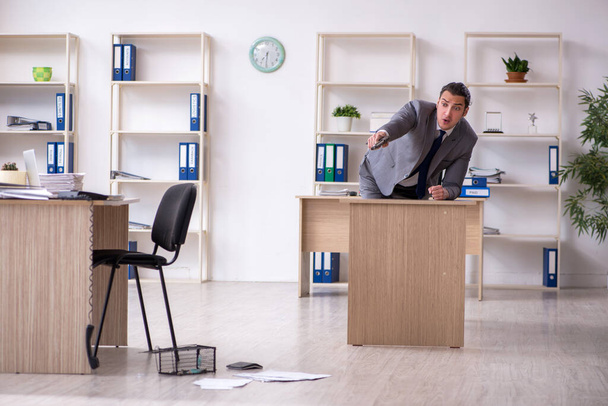 Jonge mannelijke werknemer en muizenval op kantoor - Foto, afbeelding