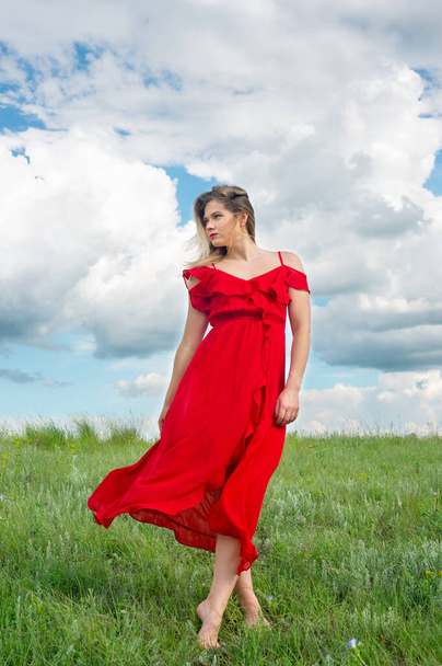 Beautiful tender woman in red dress stand on green grass - Fotografie, Obrázek