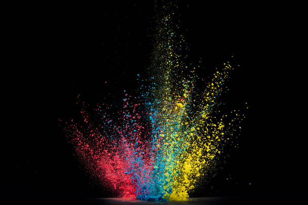 Explosion of colored powder isolated on black background. Abstract colored background - Фото, изображение