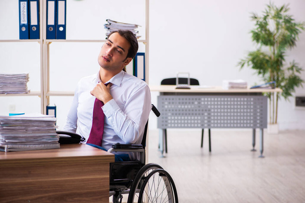Молодий чоловік після аварії на інвалідному візку на робочому місці
 - Фото, зображення