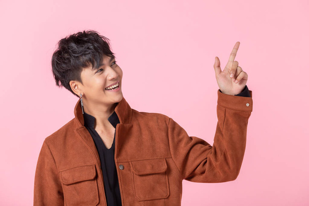 Asian a man handsome young pointing with two hands and fingers to the side eyes looking at camera in love isolated on pink blank copy space studio background. - Фото, зображення