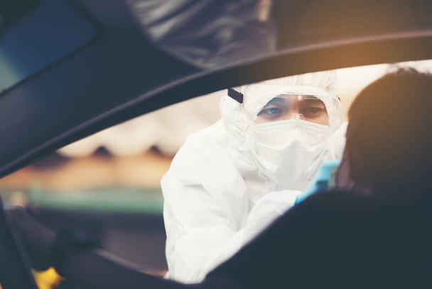 Aziatische vrouw rijden Thru Covid-19 testen met PPE medisch personeel, COVID testen van de temperatuur tijdens het controleren van auto 's - Foto, afbeelding