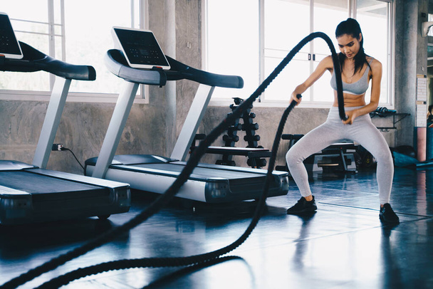 Mulheres cardio trabalhando treinamento com corda de batalha musculação atividade conceito saudável - Foto, Imagem