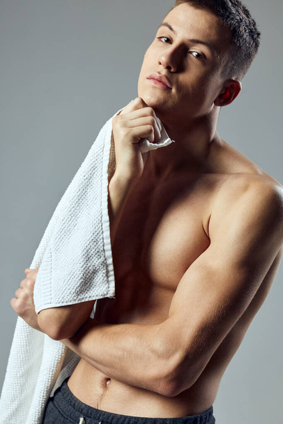 sporty man pumped up body with towel in hands close-up cropped view - 写真・画像