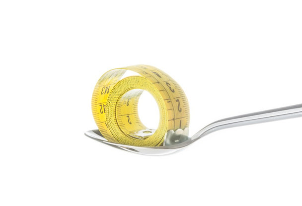 measuring tape on spoon, concept of nutrition and diet - Fotó, kép
