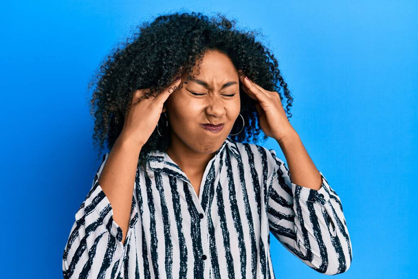 Beautiful african american woman with afro hair wearing casual clothes with hand on head, headache because stress. suffering migraine.  - Photo, Image