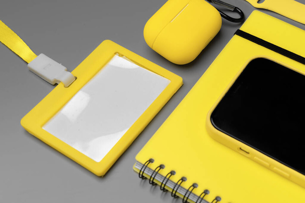 Yellow notepad, smartphone and earphones on gray background - Zdjęcie, obraz
