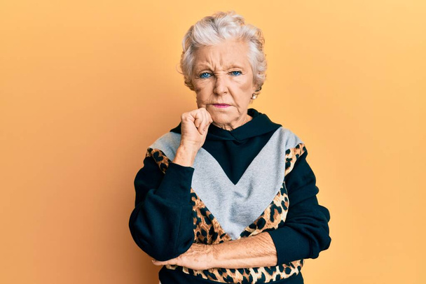 Senior grijs-harige vrouw draagt sportkleding denken geconcentreerd over twijfel met de vinger op de kin en kijken omhoog afvragen  - Foto, afbeelding