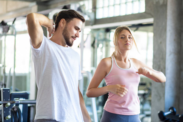 Couple sportif étirant le muscle avant l'activité sportive dans le club de gym fitness exercice heureux ensemble - Photo, image