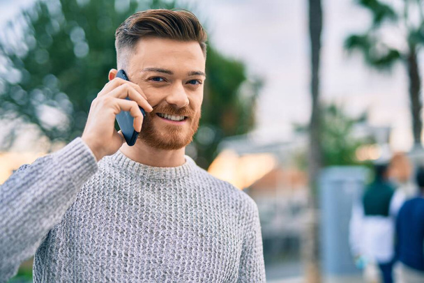 Young caucasian man smiling happy talking on the smartphone at the city. - Fotoğraf, Görsel