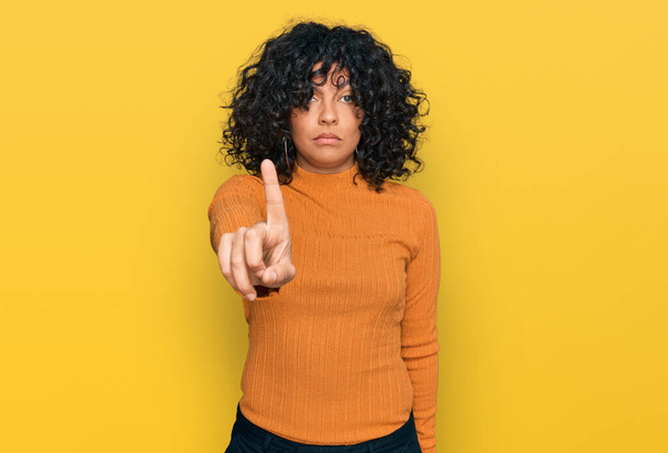 Jonge Latijns-Amerikaanse vrouw draagt casual kleding wijzen met de vinger omhoog en boze uitdrukking, tonen geen gebaar  - Foto, afbeelding