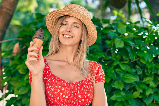 Jovem loira turista vestindo estilo de verão comendo sorvete no parque. - Foto, Imagem
