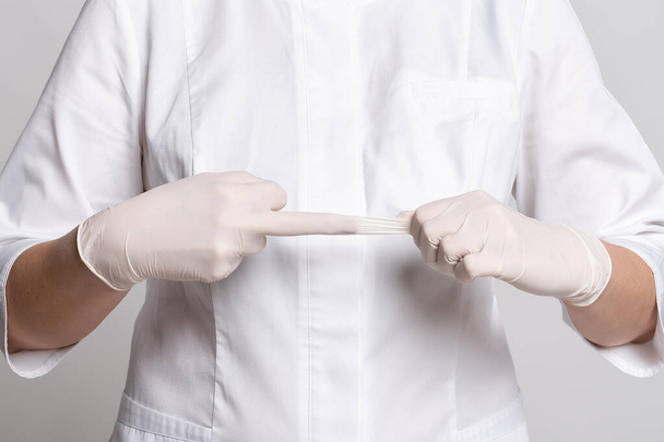 Vista ritagliata del medico in guanti di lattice bianco per virus protettivo. Proteggiti. Medicina e concetto di assistenza sanitaria - Foto, immagini