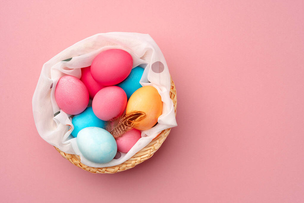 Painted Easter eggs in decorative nest on pink background - Valokuva, kuva