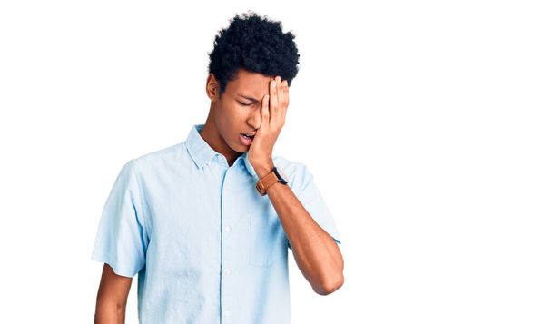 Junger afrikanisch-amerikanischer Mann in lässiger Kleidung gähnt müde und bedeckt mit der Hand das halbe Gesicht, Augen und Mund. Gesicht schmerzt vor Schmerzen.  - Foto, Bild