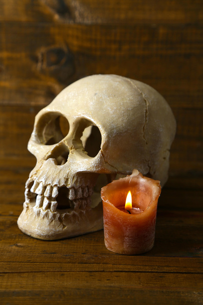 Skull and candle on wooden background - Valokuva, kuva