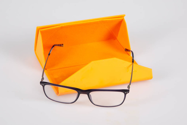 Brýle nové a oranžové pouzdro na šedém pozadí - Fotografie, Obrázek