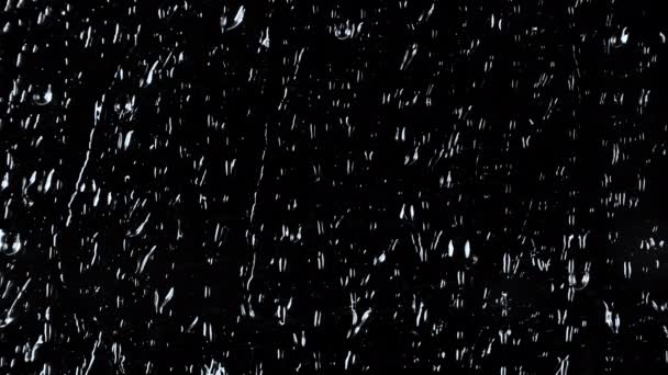 Imágenes en cámara lenta de 4k de gotas sobre fondo de vidrio negro - Imágenes, Vídeo