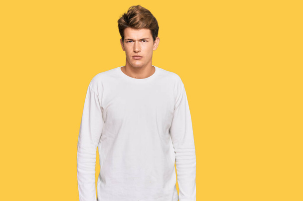 Handsome caucasian man wearing casual white sweater relaxed with serious expression on face. simple and natural looking at the camera.  - Photo, Image