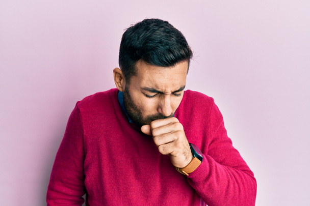 Jonge Latijns-Amerikaanse man draagt casual kleding gevoel onwel en hoesten als symptoom voor verkoudheid of bronchitis. Gezondheidszorgconcept.  - Foto, afbeelding