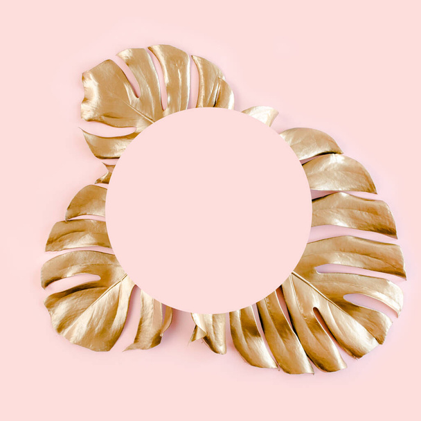 Gold tropical palm leaves Monstera on pink background. Flat lay, top view minimal concept. - Фото, зображення