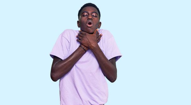 Nuori afrikkalainen amerikkalainen mies päällään rento vaatteita huutaa ja tukehtua, koska tuskallinen kuristaa. terveysongelma. tukehtuminen ja itsemurha-ajatus.  - Valokuva, kuva