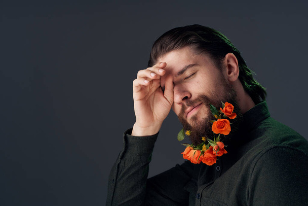 Елегантний чоловік з квітами в бороді, прикрасою, студійним фоном. Високоякісна фотографія
 - Фото, зображення