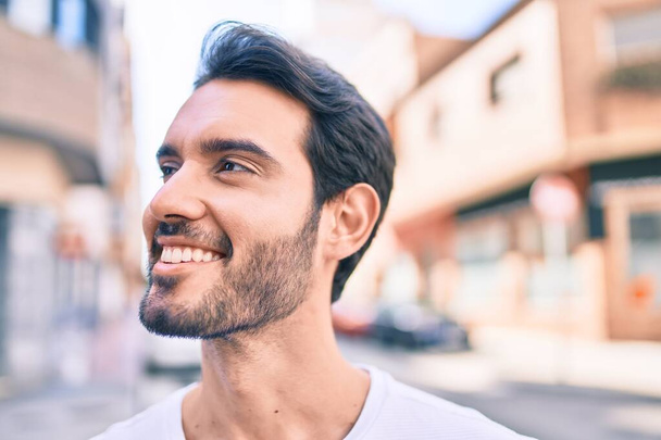 Молодий іспаномовний чоловік посміхається щасливою ходою по місту
. - Фото, зображення
