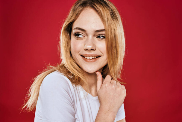 Hübsche Frau lächeln weißes T-Shirt abgeschnittene Äste roter Hintergrund - Foto, Bild