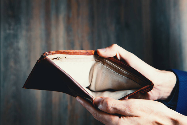man holds an empty wallet in his hands. - Foto, Bild