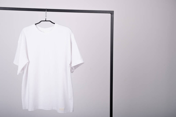 Camiseta sobre fondo claro sin inscripciones. Ropa hecha de materiales naturales, algodón. Una maqueta de camiseta blanca para mujeres. Foto de alta calidad - Foto, imagen
