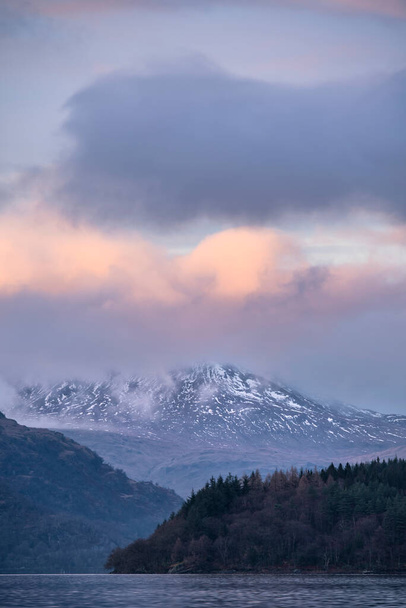Prachtig landschapsbeeld over Loch Lomond kijkend naar besneeuwde bergtop Ben Lui in Schotse Hooglanden - Foto, afbeelding