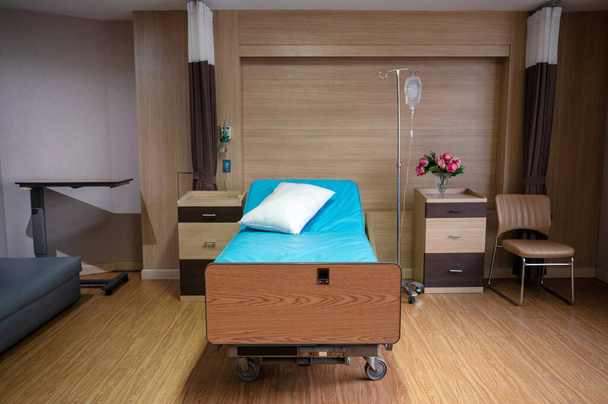 Κενό ρυθμιζόμενο κρεβάτι ασθενούς με αλατούχο διάλυμα σε ιδιωτικό χώρο στο θάλαμο του νοσοκομείου - Φωτογραφία, εικόνα