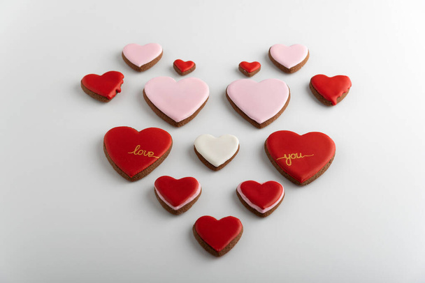 Biscotti a forma di cuore con glassa colorata di zucchero. Sfondo bianco. San Valentino - Foto, immagini