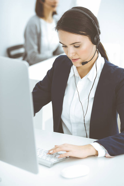 Call center. Beautiful woman sitting and working in headset at customer service office. Business concept - Fotó, kép